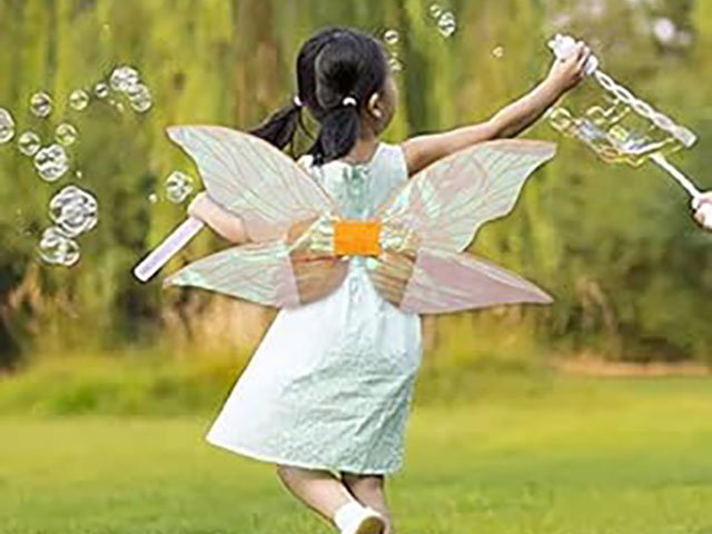 Photo d'une petite fille faisant des bulles et déguisée en fée pour un stage d'été sur le thème des fées