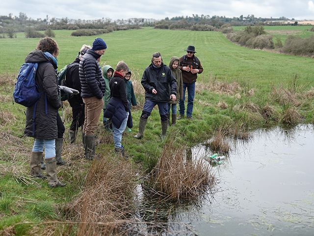 Photo d'un groupe d'adultes recevant des informations sur un étang